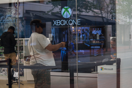 PORTLAND, OREGON SEPTEMBER 09 2017, A  man of African decent wearing a headset and playing an immersive virtual reality game at a downtown electronics store.のeditorial素材