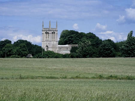 view of local country parish church across farmland northamptonshire midlands england uk