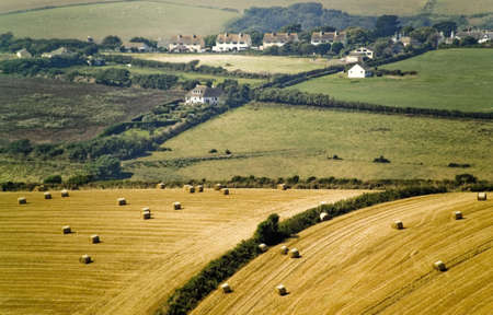 rooling english countryside with harvested haybalesの写真素材