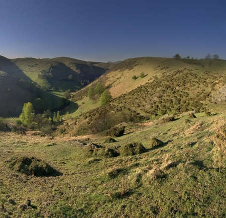 mountain peak sunlit footpath and moody cloudsの写真素材