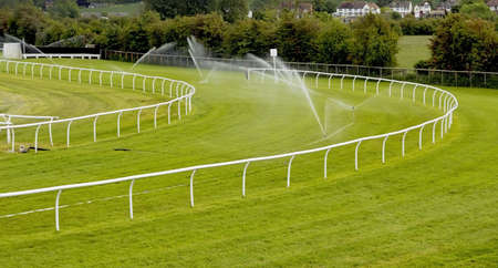 sprinklers watering racecourseの写真素材