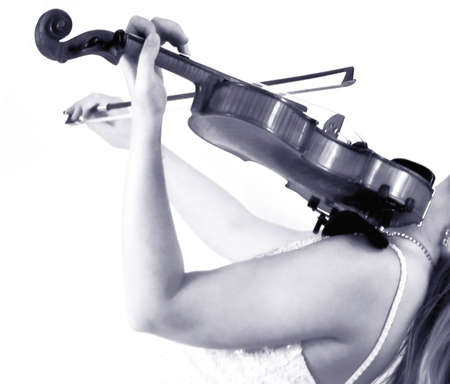 young woman playing violin in evening dress at concert 
