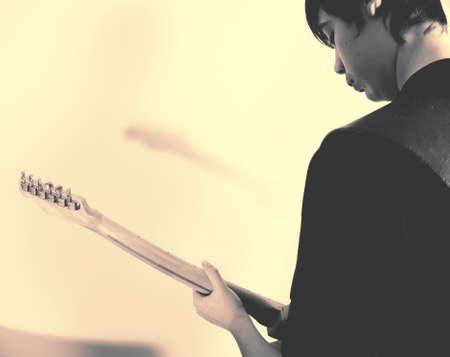 14 year old teenage boy playing punk rock on a vintage blonde fender telecaster type guitar in rehearsal room on performing arts courseの写真素材