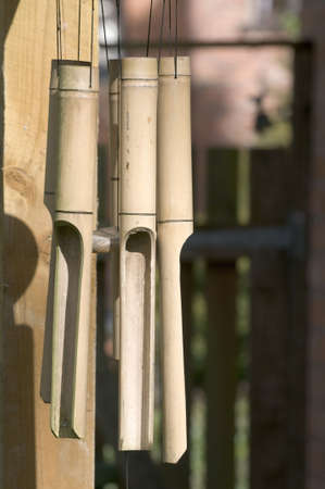 bamboo wind chimes hanging from roof in gardenの写真素材