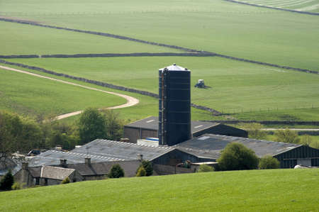 farm in the middle of farmland and fieldsの写真素材