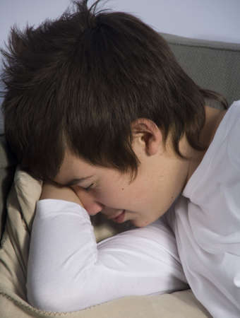 teenage boy sleeping on couchの写真素材