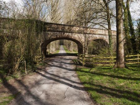 railway bridge over road country lane footpath countrysideの写真素材