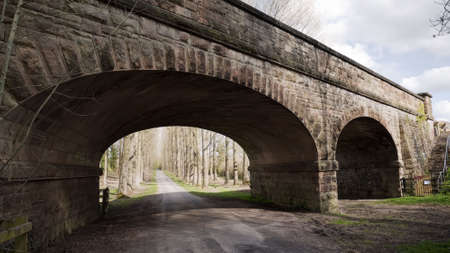 railway bridge over road country lane footpath countrysideの写真素材