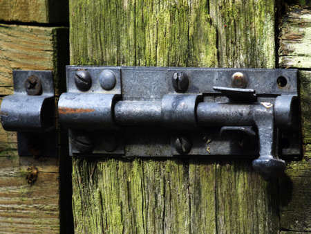 locks and bolts on old wooden gate made of woodの写真素材