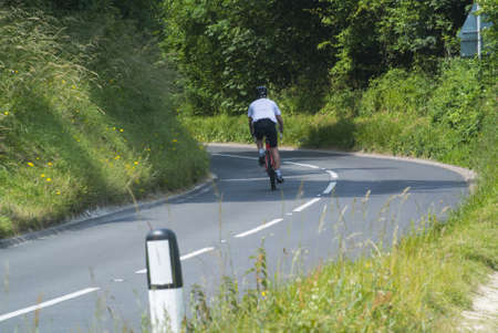 young man cycling down a hill in the south downs national park, sussex, uk の写真素材