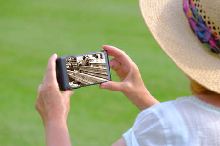 Senior woman with smartphone looking at wedding picture