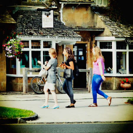 Visitors and tourists on the high street broadway village in the Cotswolds Worcestershire England UKの素材