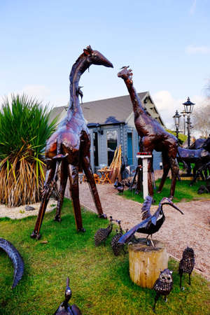 Metal garden sculptures of animals in a garden centreの素材