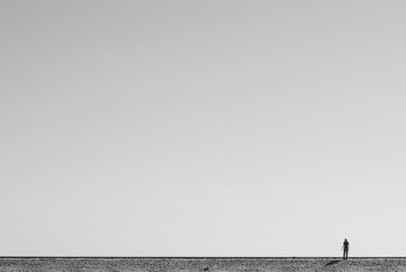 Lonely man on the beach. Black and white photo.の写真素材