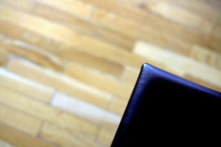 Close up of black leather chair on wooden floor background with copy spaceの写真素材