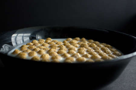 Bowl of cornflakes on dark background.の写真素材