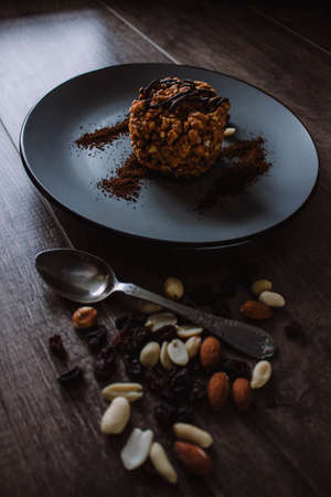 Anthill cake with chocolate and coffee on a dark background. Dessert with nuts and raisins. Bolo...