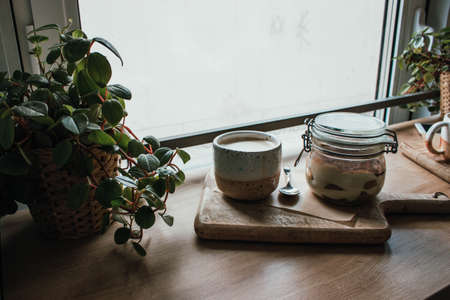 High angle view of tiramisu in glass cup with coffee cappuccino. In vegan shop, local cozy cafe. Wooden background, candid style. Copy spaceの写真素材