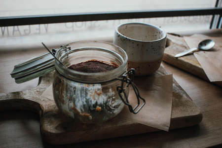 High angle view of tiramisu in glass cup with coffee cappuccino. In vegan shop, local cozy cafe....