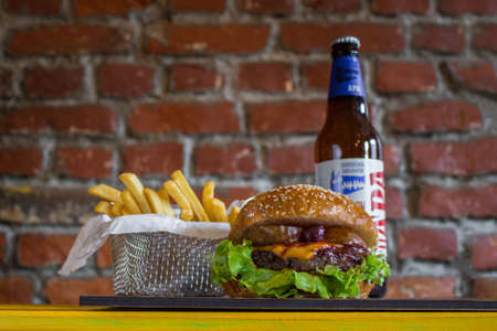 Homemade burgers with beef pear and cherry and french fried potatoes and bottle of cold beer on...