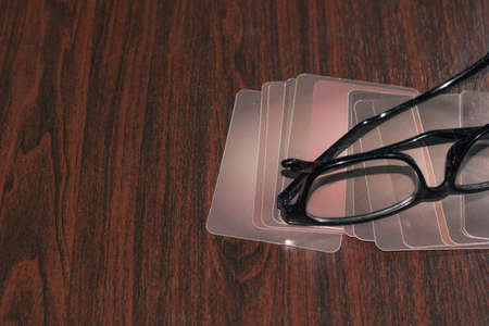 Black glasses resting on a deck of gray cards