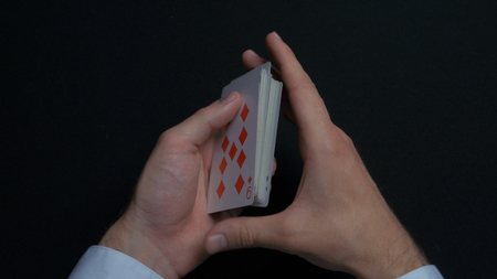 Poker game - shuffling cards. Mans hands shuffing cards. Close up. Mans hands shuffling playing cards. Dealers hands shuffling cards during a poker gameの写真素材