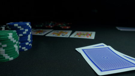 Person showing his deck at the poker game. Card player checks his hand, two aces in, chips in background on green playing table, focus on card. Hand of two aces in pokerの写真素材
