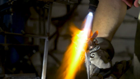 Blacksmith makes an iron rose. Man makes a rose out of ironの写真素材