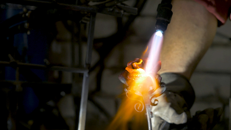 Blacksmith makes an iron rose. Man makes a rose out of ironの写真素材