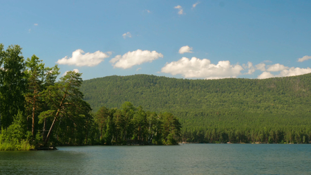 Beautiful lake view. Summer landscape with blue sky, trees and lake, timelapseの写真素材