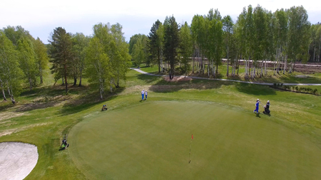 Aerial view of golfers playing on putting green. Professional players on a green golf course.の写真素材