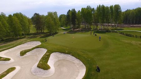 Aerial view of golfers playing on putting green. Professional players on a green golf course.の写真素材