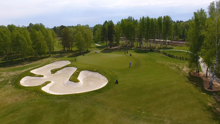 Aerial view of golfers playing on putting green. Professional players on a green golf course.の写真素材
