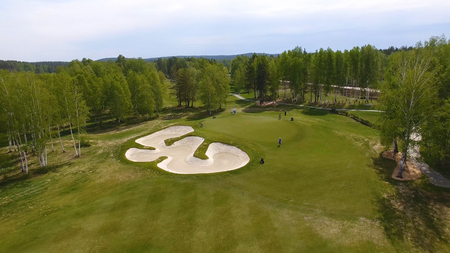 Aerial view of golfers playing on putting green. Professional players on a green golf course.の写真素材