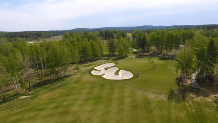 Aerial view of golfers playing on putting green. Professional players on a green golf course.の写真素材