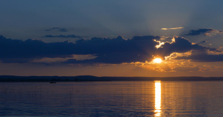 Sunset over lake. clouds. Water. San in the skyの写真素材