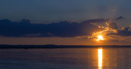 Sunset over lake. clouds. Water. San in the skyの写真素材