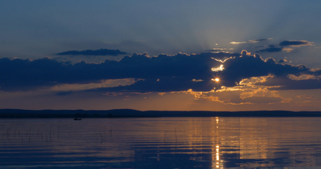Sunset over lake. clouds. Water. San in the skyの写真素材