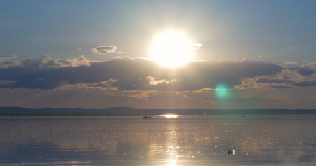 Sunset over lake. clouds. Water. San in the skyの写真素材