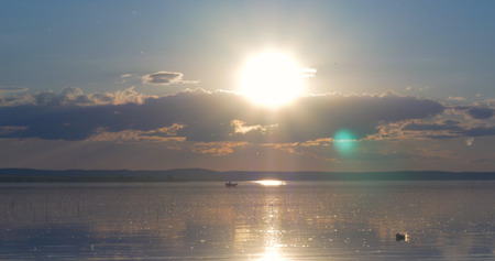 Sunset over lake. clouds. Water. San in the skyの写真素材