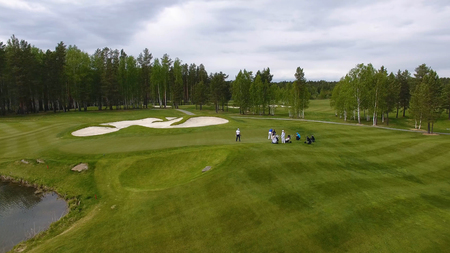 Golfers hitting golf shot with club on course while on summer vacation, aerial.の写真素材