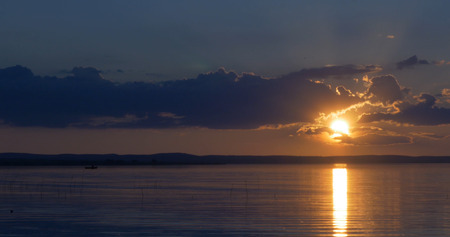Sunset over lake. clouds. Water. San in the skyの写真素材