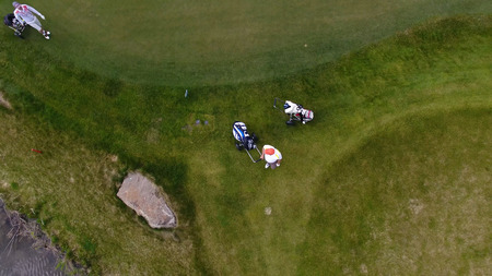 Aerial view Golf course. Golfers walking down the fairway on a course with golf bag and trolley.の写真素材