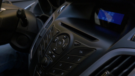 Mans hand puts the disk into the car player. Button control for compact disk player in a car. Hand puts the disk into the radio carの写真素材