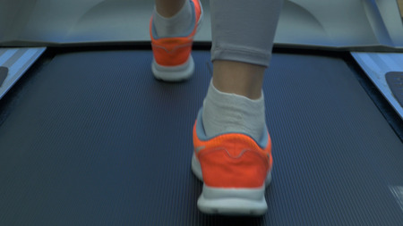 Womans muscular legs on treadmill. womans muscular legs on treadmill, closeup. girls legs on...