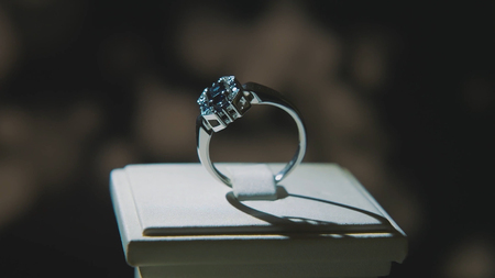 Precious diamond rings. Fine luxury diamond jewellery window display with ring pedant. Gold ring with brilliant isolated on black backgroundの写真素材