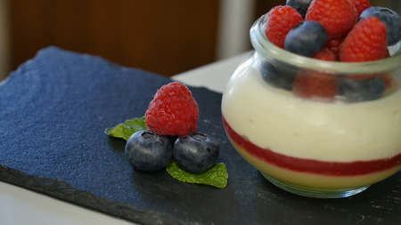 Homemade yogurt with blueberries in a glass jar. beautifully arranged berries to decorate the...