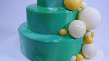 Stylish mousse cake with turquoise mirror glaze. Cake with turquoise mirror glaze decorated with chocolate balls.の写真素材