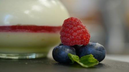 Homemade yogurt with blueberries in a glass jar. beautifully arranged berries to decorate the dessert, close up.の写真素材