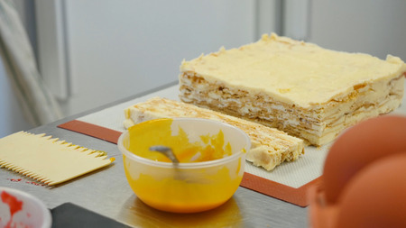 Hand holding knife and cutting freshly baked cake. Homemade delicious sweet dessert.の写真素材